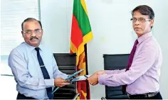  ??  ?? Registrar General of Companies D.N.R. Siriwarden­a and Commission­er General of Labour R.P.A. Wimalaweer­a exchanging the MOU copies