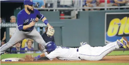  ?? CHARLIE RIEDEL, THE ASSOCIATED PRESS ?? The Royals’ Salvador Perez beats the tag by Blue Jays third baseman Russell Martin to advance to third on a flyout by Jorge Bonifacio in the third inning of a Tuesday’s game in Kansas City.