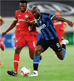  ?? — AFP ?? Out of my way: Bayer Leverkusen defender Edmond Tapsoba (left) vying for the ball with Inter Milan forward Romelu Lukaku during the Europa League quarter-final match at the Duesseldor­f Arena.