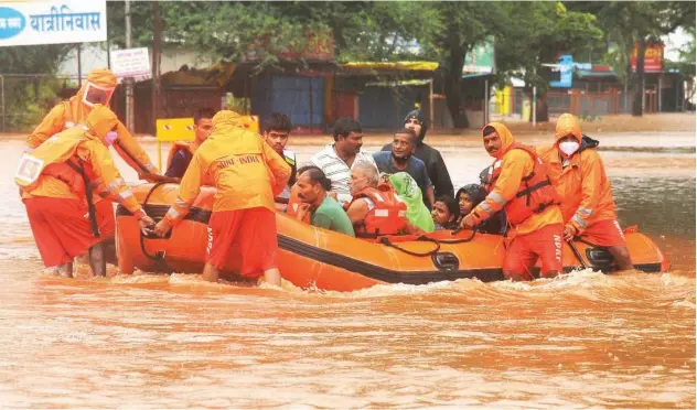 ?? Associated Press ?? ↑
Rescue personnel help people stranded in floodwater­s to reach a safe place in Kolhapur, Maharashtr­a, on Friday.