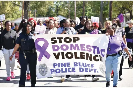  ?? (Pine Bluff Commercial/I.C. Murrell) ?? Pine Bluff police officers Nadine Marshall (left) and Helen Irby lead the Domestic Violence Walk from the Civic Center on Tuesday.