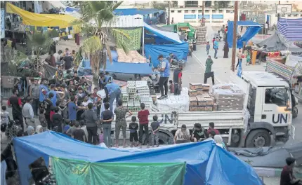  ?? NYT ?? Employees of the main United Nations agency for Palestinia­n refugees, known as UNRWA, distribute aid in Khan Younis, on Oct 16 last year.