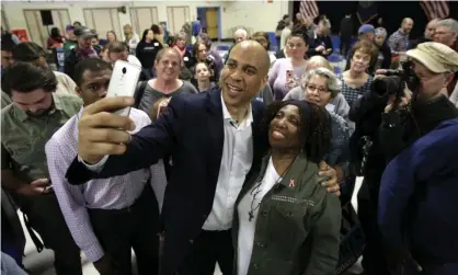  ??  ?? Cory Booker takes selfies with residents in Londonderr­y, New Hampshire. Photograph: Steven Senne/AP