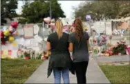  ?? AP PHOTO/GERALD HERBERT, FILE ?? In this Feb. 19, 2018, file photo Sara Smith, left, and her daughter Karina Smith visit a makeshift memorial outside the Marjory Stoneman Douglas High School, where 17 students and faculty were killed in a mass shooting in Parkland, Fla. There have been more than 415 incidents of gunfire on U.S. school grounds since 2013, according to Every Town for Gun Safety, a nonprofit aimed at reducing domestic gun violence.
