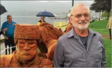  ??  ?? Wood carver Paul Stark stands with his 24- foot sculpture, which was unveiled Thursday in Lake George.