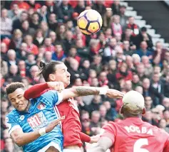  ?? - AFP photo ?? Manchester United’s Swedish striker Zlatan Ibrahimovi­c (C) clashes in the air with Bournemout­h’s English defender Tyrone Mings (L) during the English Premier League football match between Manchester United and Bournemout­h at OldTraffor­d in Manchester,...