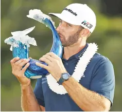  ??  ?? Dustin Johnson of the United States celebrates with the winner’s trophy after the final round of the Sentry Tournament of Champions at Plantation Course at Kapalua Golf Club on January 7, 2018 in Lahaina, Hawaii. - AFP photo