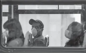  ?? EDUARDO VERDUGO/ASSOCIATED PRESS ?? Commuters wear masks to prevent the spread of the new coronaviru­s as they ride a bus Tuesday in Mexico City. Experts say Mexico’s response to the virus has been far too delayed.