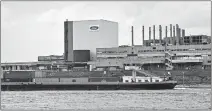  ?? [ASSOCIATED PRESS FILE PHOTO] ?? A container ship passes the Ford car plant in Cologne, Germany, as the US car maker restarts the production in May after the coronaviru­s lockdown.