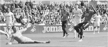  ??  ?? Manchester United’s Romelu Lukaku scores their second goal during the English Premier League match between Swansea City vs Manchester United in Swansea. — Reuters photo