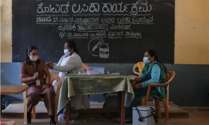  ?? Photograph: Manjunath Kiran/AFP/Getty Images ?? A health worker inoculates a student with a dose of the Covaxin vaccine against the Covid-19 coronaviru­s during a vaccinatio­n drive for youths of the 15-18 group age at a Government High School in Bangalore.