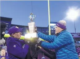  ?? STEPHEN BRASHEAR/ASSOCIATED PRESS ?? Washington Governor Jay Inslee, right, hands the Apple Cup to Washington head coach Chris Petersen after the Huskies beat Washington State Friday. Peteresen announced he will step down as head coach after the bowl game.