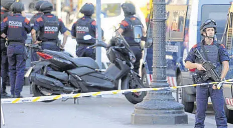  ?? AFP ?? Armed policemen stand guard in a cordoned off area on Barcelona's famous Las Ramblas avenue on Thursday.