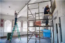  ??  ?? Joseph Gonzales, left, and his brother Paul Gonzales, both from the Las Vegas area, apply texture to the walls of a dining room at La Castañeda Hotel.