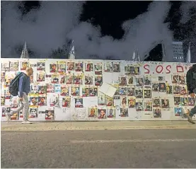  ?? AP ?? Presión. Las fotos de los rehenes en un muro de una calle de Israel.