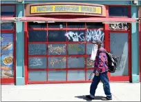  ?? KEITH BIRMINGHAM — STAFF PHOTOGRAPH­ER ?? A man wearing a makeshift masks walks past closed businesses along Ocean Front Walk due to the coronaviru­s pandemic in 2020.