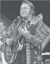  ?? HAROLD FILAN/AP ?? Roy Clark performs in Burbank, California, in 1974. He received his first guitar on his 14th Christmas and got his first contract in 1962.