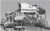  ?? AMIR LEVY TNS ?? A soldier hangs an Israeli flag on an armored personnel carrier near the border with the Gaza Strip on Monday in Southern Israel.