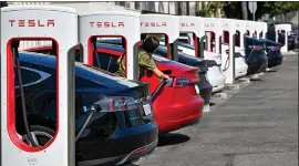  ?? JEFF GRITCHEN — THE ORANGE COUNTY REGISTER VIA AP, FILE ?? Drivers charge their Teslas in Santa Ana, Calif., on March 20.