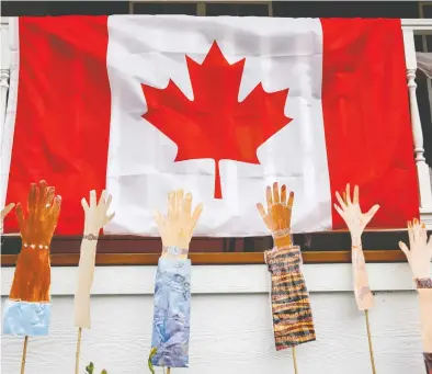  ?? JEFF MCINTOSH / THE CANADIAN PRESS FILES ?? Hand painted arms signifying Canada's racial diversity are displayed on a home on Canada Day in Airdrie, Alta., on
July 1, 2020. The country appears to have lost some of the enthusiasm for multicultu­ralism that it once held.