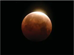  ?? RINGO H.W. CHIU — THE ASSOCIATED PRESS ?? Light shines from a total lunar eclipse over Santa Monica Beach in Santa Monica in May 2021. A total lunar eclipse will grace the night skies this weekend, providing longer than usual thrills for stargazers across North and South America.