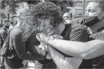  ?? RAMON ESPINOSA/AP ?? A plaincloth­es police officer detains an anti-government protester in Havana on Sunday when demonstrat­ions occurred against ongoing food shortages and other deprivatio­ns in several cities across Cuba.