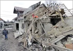  ?? The Associated Press ?? A villager passes by debris of private houses ruined in Russia’s night rocket attack in a village, in Zolochevsk­y district in the Lviv region, Ukraine, Thursday.