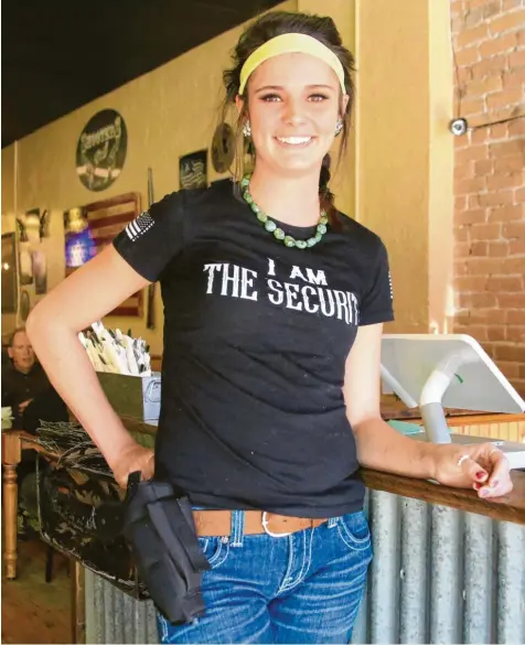  ?? Foto: Steve Przybilla ?? Freundlich­es Lächeln, Pistole am Gürtel: Kellnerin Morgan vom Restaurant „Shooters Grill“in Rifle. Auf ihrem T‰shirt steht: „Ich bin die Sicherheit“.