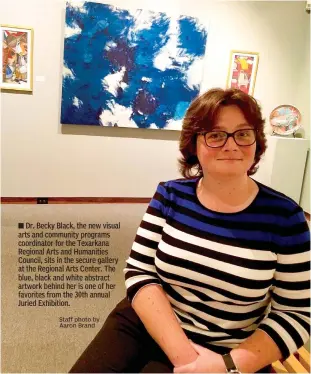  ?? Staff photo by Aaron Brand ?? ■ Dr. Becky Black, the new visual arts and community programs coordinato­r for the Texarkana Regional Arts and Humanities Council, sits in the secure gallery at the Regional Arts Center. The blue, black and white abstract artwork behind her is one of her favorites from the 30th annual Juried Exhibition.