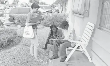  ?? JIM RASSOL/STAFF PHOTOGRAPH­ER ?? Hannah Klein, left, and Alisha Erves, center, of Nextgen Florida register John Thomas in his front yard in Fort Lauderdale. They’re among the 50 paid organizers and hundreds of volunteers working to help Andrew Gillum’s candidacy.