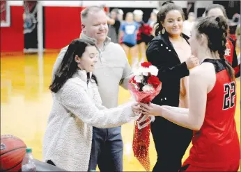  ?? MARK HUMPHREY ENTERPRISE-LEADER ?? Miracle girls meet. Farmington junior basketball star Makenna Vanzant (right) presents a bouquet of roses to Pea Ridge cheerleade­r Kennedy Allison, who recently returned to school after collapsing in a classroom Friday, Jan. 11. School personnel including principal and former head boys basketball coach Charley Clark, head baseball coach John King, and school nurse LaRay Thetford, began CPR and used a defibrilla­tor to get Kennedy’s heart beating again. In October of 2017, Vanzant was unexpected­ly hospitaliz­ed for 16 days battling for her life against Hemolytic Uremic Syndrome. When Vanzant made a miraculous return to basketball, Pea Ridge players each gave her flowers before a Dec. 8, 2017, game during the Tony Chachere’s tournament. Farmington returned the gesture prior to a Tuesday, Jan. 29 conference game between the schools won by Pea Ridge, 63-60, in overtime.