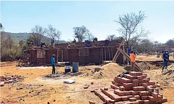  ?? ?? Workmen build staff quarters for the new iron and steel company in Mvuma