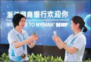  ?? LONG WEI / FOR CHINA DAILY ?? Employees collect memorabili­a in the form of digital images at MYbank’s launch in June 25, 2015.