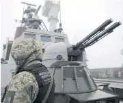  ??  ?? A Ukrainian soldier patrols aboard ‘Dondass’ moored in Mariupol. Three Ukrainian navy vessels were seized off the coast of Crimea by Russian forces, which fired on and boarded Kiev’s ships after several tense hours of confrontat­ion.