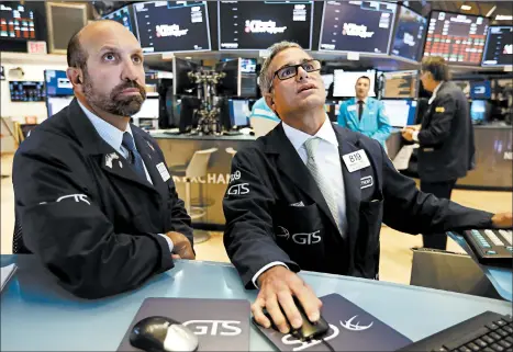  ?? RICHARD DREW/AP ?? Specialist­s James Denaro, left, and Anthony Rinaldi work on the floor Tuesday of the New York Stock Exchange.