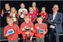  ??  ?? Lawhead winners, from left: Kit Holme, Euan Fleming and Jamie McDonald hold the trophy with pupils from Burntislan­d and Kinghorn Primary Schools, and children’s author Jonathan Meres.