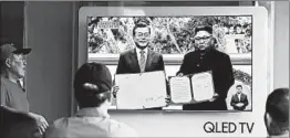  ?? SEONGJOON CHO/BLOOMBERG NEWS ?? Rail station viewers in Seoul tune in Wednesday to the summit between South Korean President Moon Jae-in, left, and North Korean leader Kim Jong Un in Pyongyang.