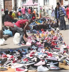  ??  ?? Some street vendors conducting their business along First Street in Harare yesterday despite efforts by authoritie­s to encourage the informal traders to relocate to designated vending sites. (Picture by John Manzongo)