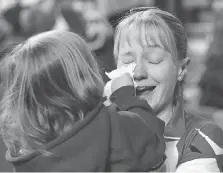  ??  ?? Kali, 3, daughter of Team Canada third Amy Nixon, wipes her mother’s tears following a 7-4 win over Northern Ontario on Sunday in the bronze medal game at the Scotties Tournament of Hearts in St. Catharines, Ont.