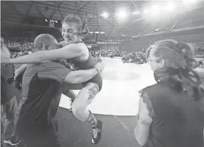  ?? ?? North Mason’s Sadie Evans jumps into the arms of coach Bill McCarty after her championsh­ip win over Napavine’s Maya Kunkel with a second period pin at Mat Classic on Saturday. Evans’ championsh­ip is a first for the Bulldogs’ girls wrestling team.