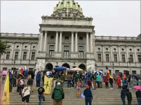  ?? MARK SCOLFORO — THE ASSOCIATED PRESS ?? People rally for gun rights on the rainy steps of the Pennsylvan­ia Capitol on Tuesday in Harrisburg.