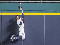  ?? RONALD MARTINEZ GETTY IMAGES ?? Mookie Betts of the Los Angeles Dodgers catches a fly ball at the wall from Freddie Freeman of the Atlanta Braves in the fifth inning in Game 7 of the National League Championsh­ip Series in Arlington, Texas, on Sunday night.