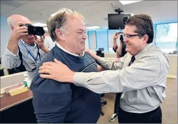  ?? Robert Casillas Daily Breeze ?? LONGTIME Daily Breeze city editor Frank Suraci, left, receives a celebrator­y hug from executive editor Michael Anastasi. Suraci couldn’t recall a time when the newspaper even submitted a story for a Pulitzer.