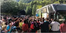 ?? Foto: STR, afp ?? Urlauber warten nach dem schweren Erdbeben in der Provinz Sichuan darauf, mit Bussen in Sicherheit gebracht zu werden.