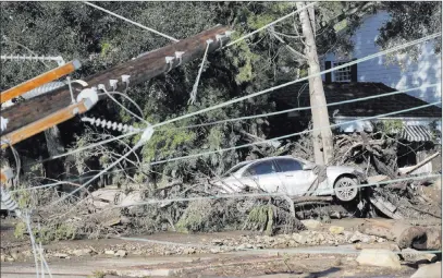  ?? Marcio Jose Sanchez ?? A damaged car sits over fallen debris and behind downed power lines Wednesday in Montecito, Calif. The Associated Press