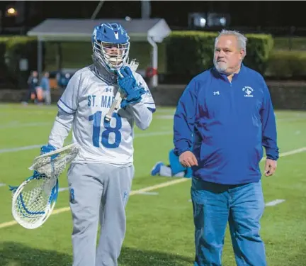  ?? KARL MERTON FERRON/STAFF ?? St. Mary’s goalkeeper Logan Earl, a senior and first-year starter, walks with his father Dave Earl, who coached Severna Park to six state titles in seven seasons, after a recent Saints game.