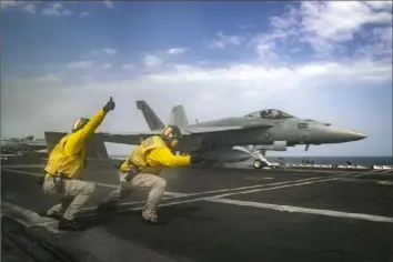  ?? Jeff Sherman/U.S. Navy ?? Lt. Nicholas Miller of Spring, Texas, and Lt. Sean Ryan of Gautier, Miss., launch an F-18 Super Hornet from the deck of the USS Abraham Lincoln aircraft carrier Thursday in the Arabian Sea.