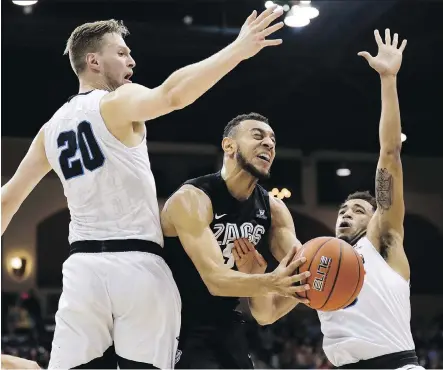  ?? GREGORY BULL/ASSOCIATED PRESS ?? Gonzaga guard Nigel Williams-Goss, centre, shoots between San Diego forward Cameron Neubauer, left, and guard Olin Carter III during NCAA action. Cinderella teams such as Gonzaga have traditiona­lly helped elevate the profile of the March Madness...