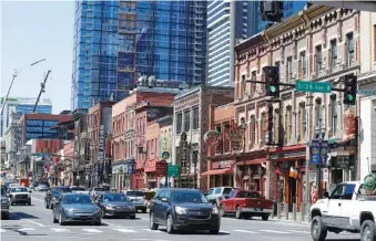  ?? AP PHOTOS/MARK HUMPHREY ?? Restaurant­s, bars and stores on Broadway in Nashville are seen in April. Nashville Mayor John Cooper announced Tuesday that bars would remain closed through the end of the month to help prevent the spread of the coronaviru­s.