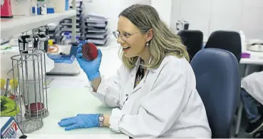  ?? Picture: Alon Skuy ?? Dr Juno Thomas in a lab at the National Institute For Communicab­le Diseases, in Johannesbu­rg. She is holding a ‘Listeria monocytoge­nes’ culture on a blood agar plate.